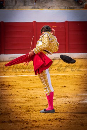 Torero lanzando la montera al aire en el brindis antes de la faena. Fotografía de ritual taurino.