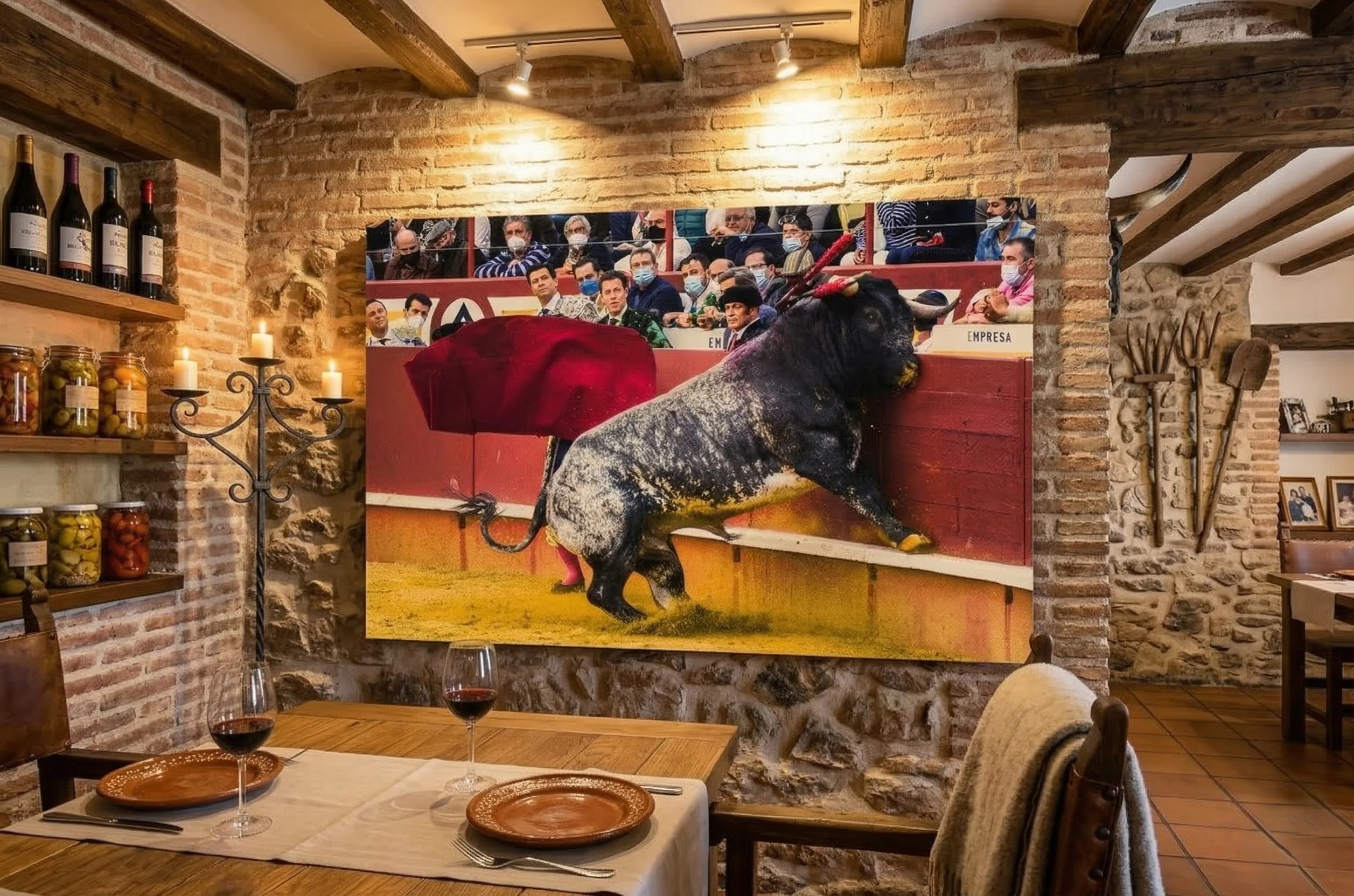 Cuadro en gran formato de la fotografía El límite de las tablas - Derrote de toro burraco, expuesto en la pared de piedra de un comedor rústico.